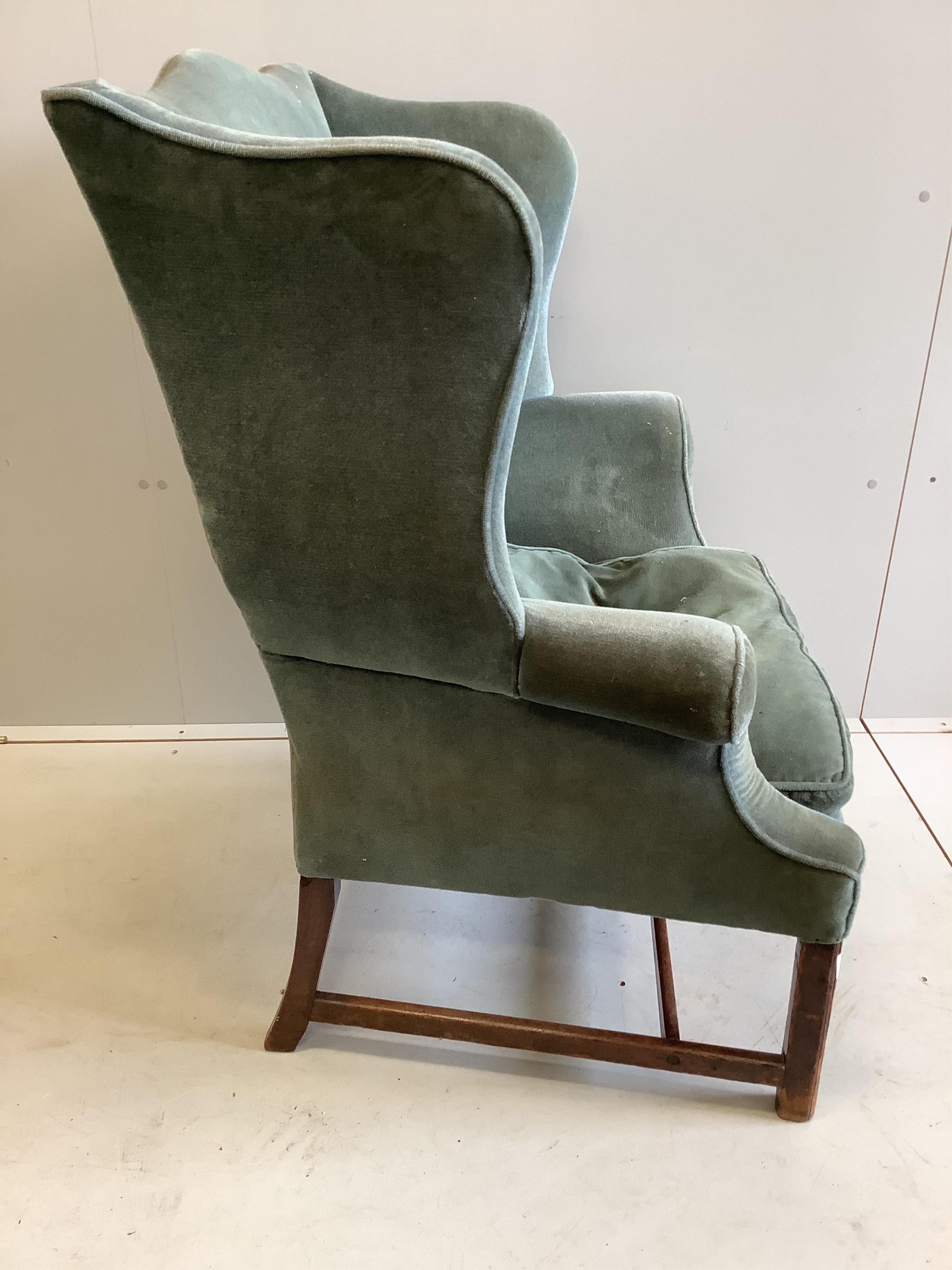 A George III upholstered wing back armchair, width 84cm, depth 64cm, height 105cm. Condition - fair